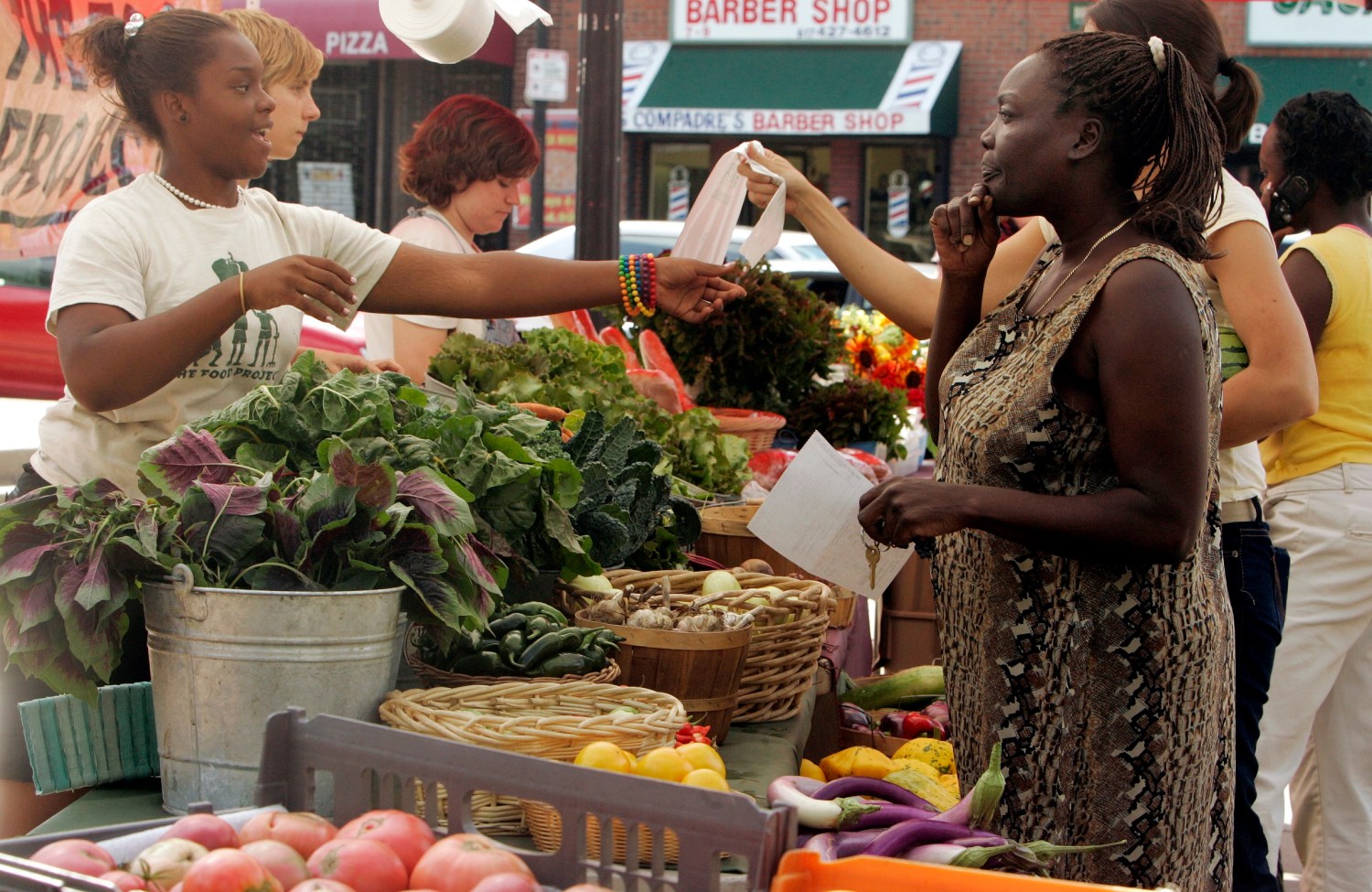 Customers shop for produce at the Food Project's Farmer's Market in the Boston neighborhood of Dorchester, Massachusetts August 14, 2007. Each year The Food Project hires 60 youth to grow food on their farms