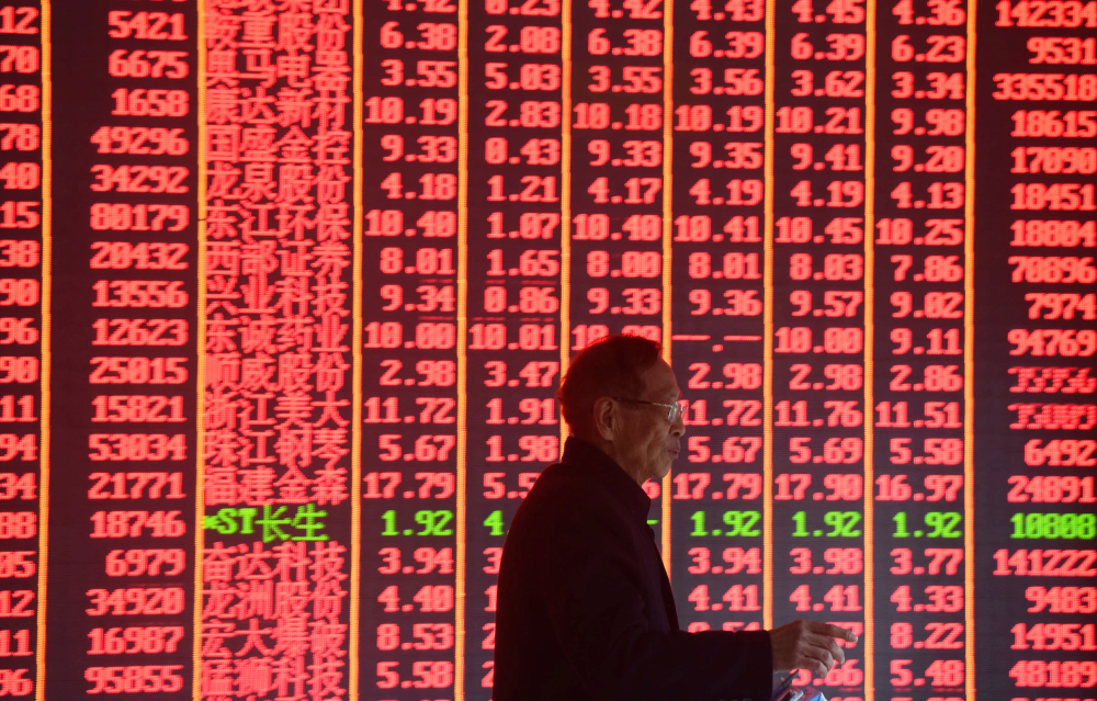 A man is seen in front of an electronic board showing stock information on the first day of trading in the Year of the Pig, following the Chinese Lunar New Year holiday, at a brokerage house in Hangzhou, Zhejiang province, China February 11, 2019. REUTERS/Stringer ATTENTION EDITORS - THIS IMAGE WAS PROVIDED BY A THIRD PARTY. CHINA OUT.