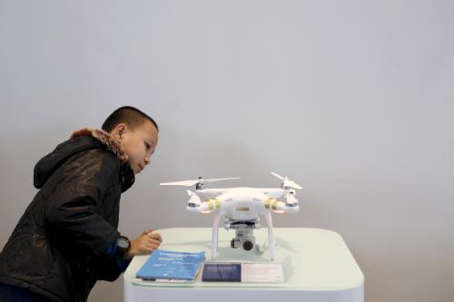 A child looks at DJI's Phantom 3 drone at their first flagship store in Shenzhen, Guangdong province, China December 20, 2015. Chinese drone developers are racking up an impressive list of aerial solutions for a growing variety of demands, from police surveillance to agricultural mapping and traffic management. Already well established as a world leader in drone manufacturing, China is slowly emerging as a world-class innovator, not just a duplicator of foreign designs. REUTERS/Tyrone Siu - GF10000272196