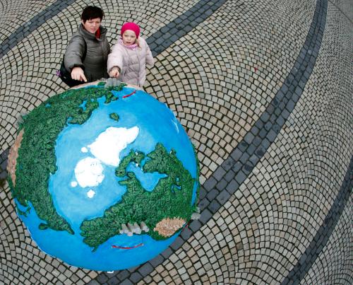 People look at a globe which is a part of of an installation in downtown Copenhagen December 6, 2009. Copenhagen is the host city for the United Nations Climate Change Conference 2009 which starts from December 7 until December 18.   REUTERS/Pawel Kopczynski  (DENMARK ENTERTAINMENT ENVIRONMENT IMAGES OF THE DAY) - GM1E5C61T3J01