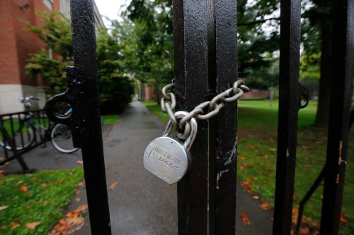 A gate to Harvard Yard is chained and locked shut at Harvard University in Cambridge, Massachusetts October 4, 2014. Security at Harvard University was stepped up after hundreds of students and staff received emails on Friday from a sender who threatened to come to the Ivy League school "tomorrow" and shoot them, according to campus police.    REUTERS/Brian Snyder    (UNITED STATES - Tags: EDUCATION CRIME LAW) - GM1EAA41OUJ01