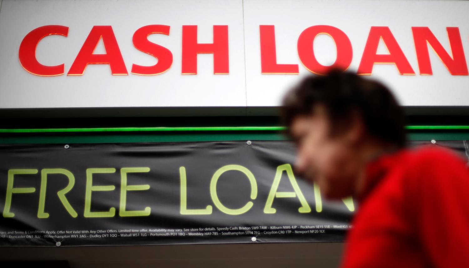 A pedestrian passes by a money lending shop in northeast London October 3, 2013.  Britain's financial watchdog drew fire on Thursday for failing to impose a cap on the huge interest rates imposed by payday lenders as it set out its plan to discipline the industry. REUTERS/Suzanne Plunkett  (BRITAIN - Tags: BUSINESS POLITICS) - LM1E9A312E601