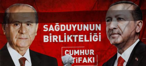 A woman walks past a banner for the upcoming local elections in Ankara, Turkey, March 27, 2019. Banner with pictures of Turkish President Tayyip Erdogan and Devlet Bahceli, leader of Nationalist Movement Party (MHP), reads: "People's Alliance: The unity of common sense." REUTERS/Umit Bektas - RC14BCF5B7C0