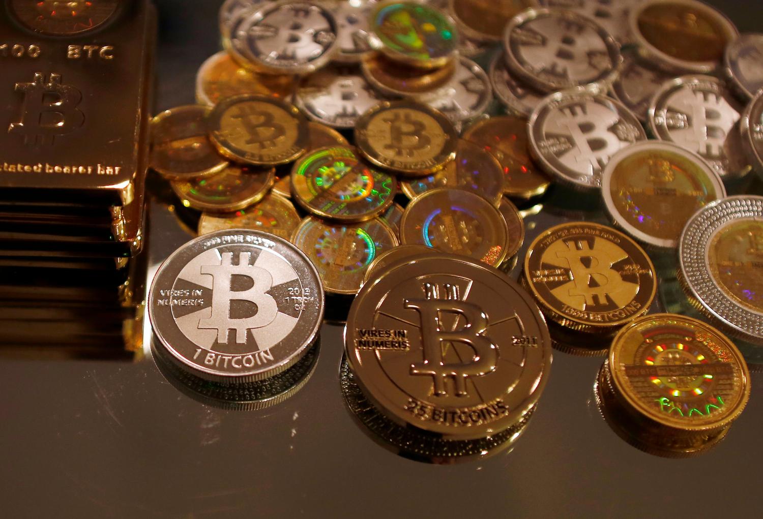 Bitcoins created by enthusiast Mike Caldwell are seen in a photo illustration at his office in Sandy, Utah, September 17, 2013. Caldwell produces physical coins Bitcoins, which have been around since 2008, are a form of electronic money that can be exchanged without using traditional banking or money transfer systems. REUTERS/Jim Urquhart  (UNITED STATES - Tags: BUSINESS SOCIETY) - GF2E99H1A2P01