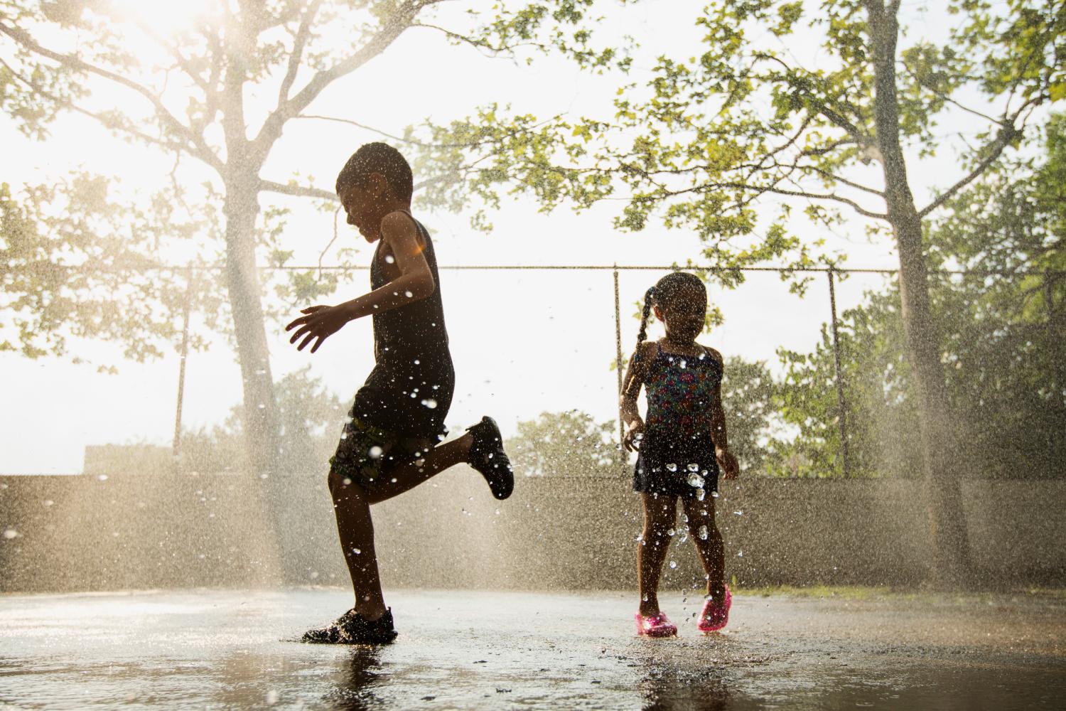 Children run through a sprinkler system installed inside a playground to cool off during a hot summer day in New York, July 17, 2013. Temperatures in New York City, the nation's biggest metropolitan area, soared into the upper 90s Fahrenheit for a third straight day on Wednesday and the National Weather Service issued heat advisories for dozens of northeastern cities and surrounding areas in Connecticut, Massachusetts, Rhode Island and upstate New York. REUTERS/Lucas Jackson (UNITED STATES - Tags: ENVIRONMENT) - GM1E97I0INZ01