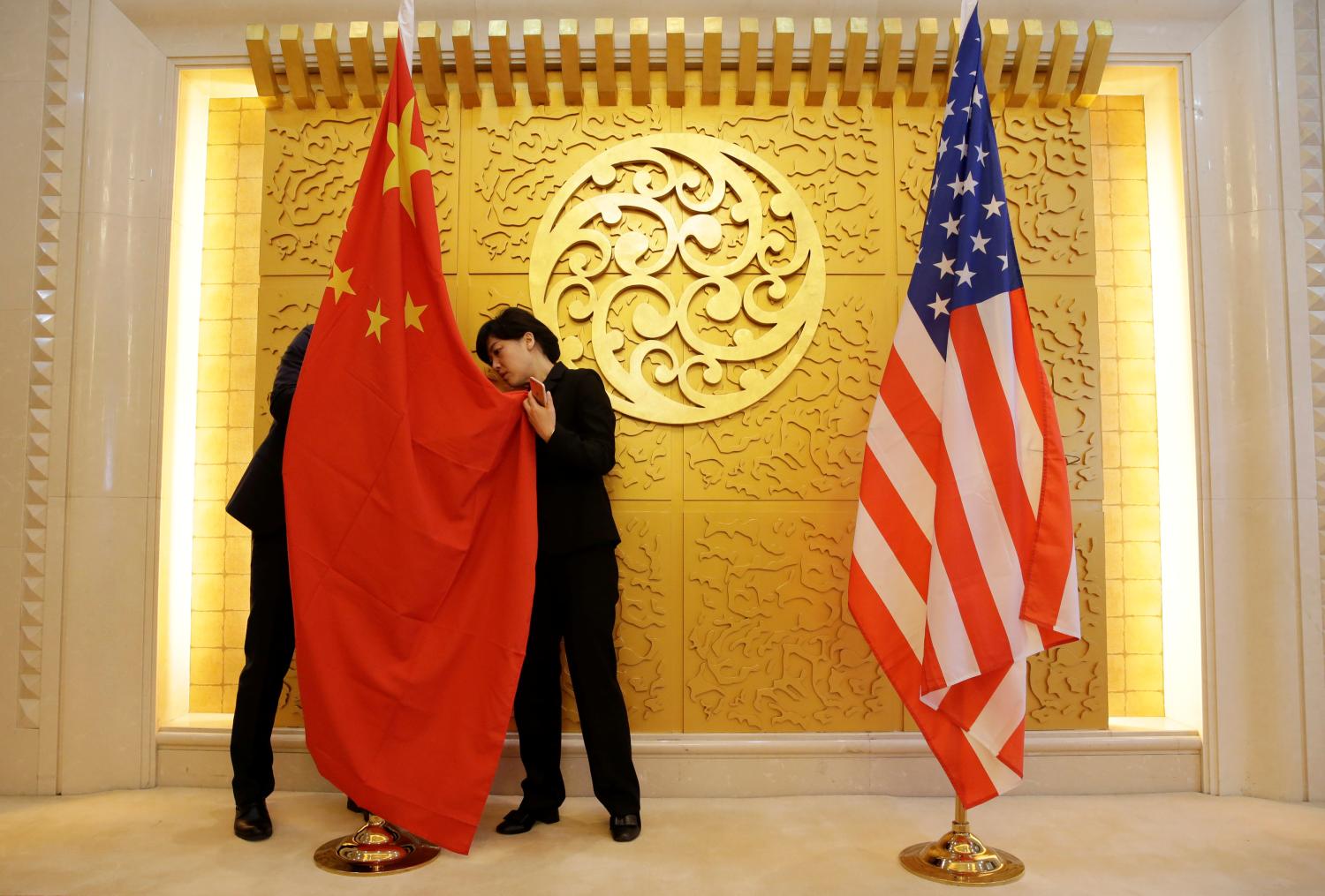 Staff members set up Chinese and U.S. flags for a meeting between Chinese Transport Minister Li Xiaopeng and U.S. Secretary of Transportation Elaine Chao at the Ministry of Transport of China in Beijing, China April 27, 2018. REUTERS/Jason Lee/Pool - RC155E3642C0