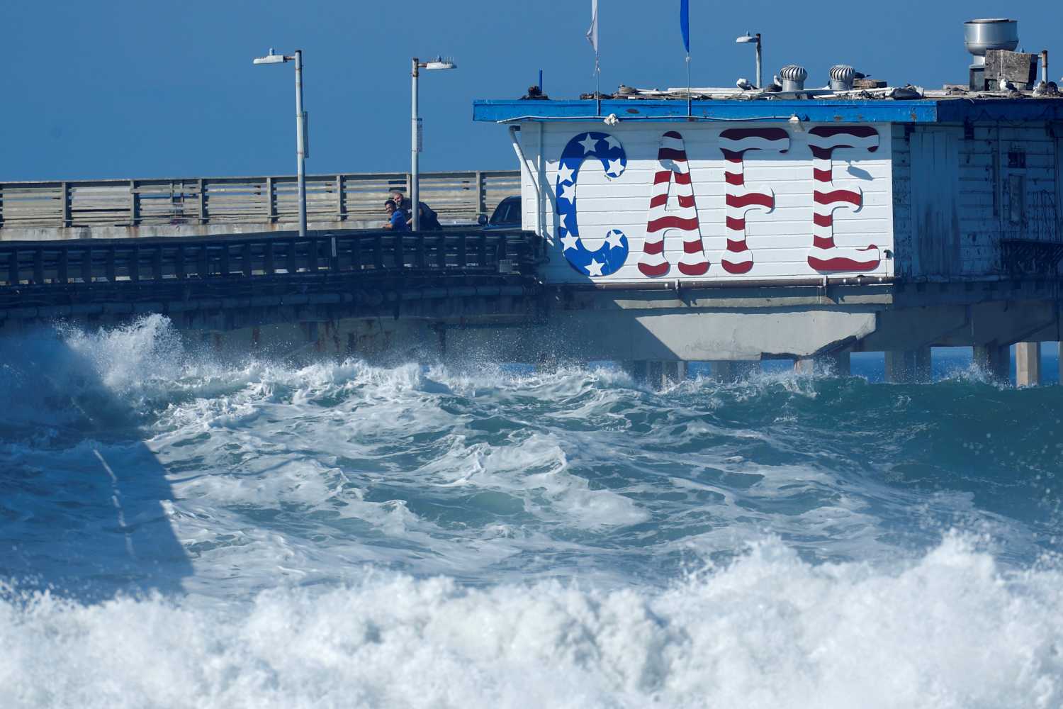 High waves come close to reaching a cafe after lifeguards closed the pier due to the large swells in Ocean Beach, California, U.S., January 9, 2019.      REUTERS/Mike Blake - RC176229A9E0
