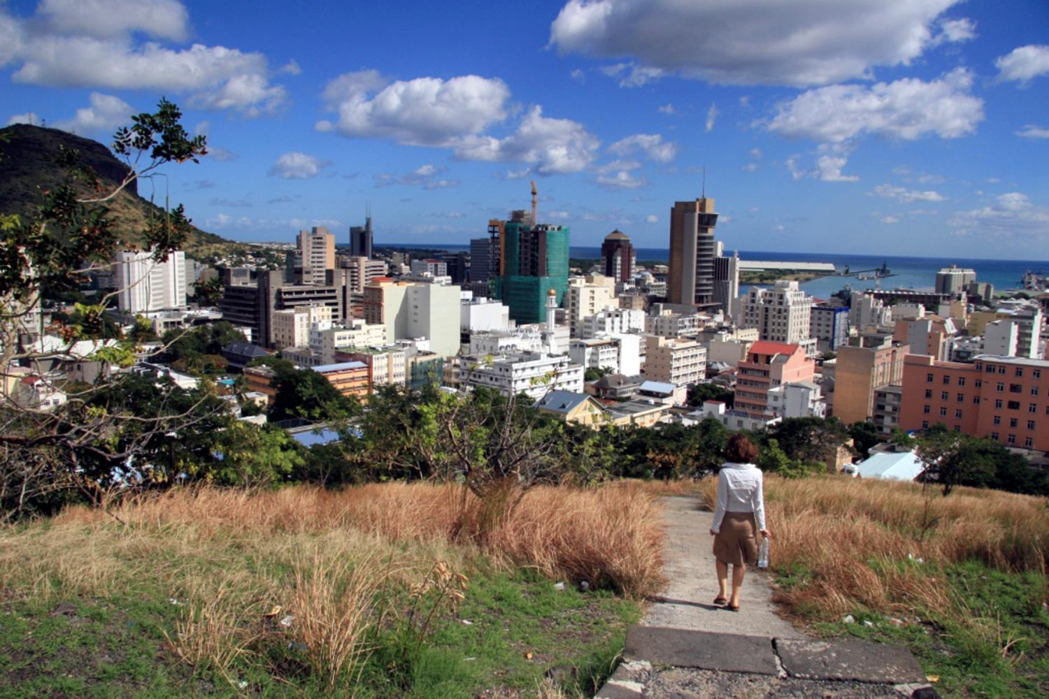 A woman walks down a hill to Port Louis June 6, 2008. REUTERS/Ed Harris (MAURITIUS) - GM1E4661HGX01