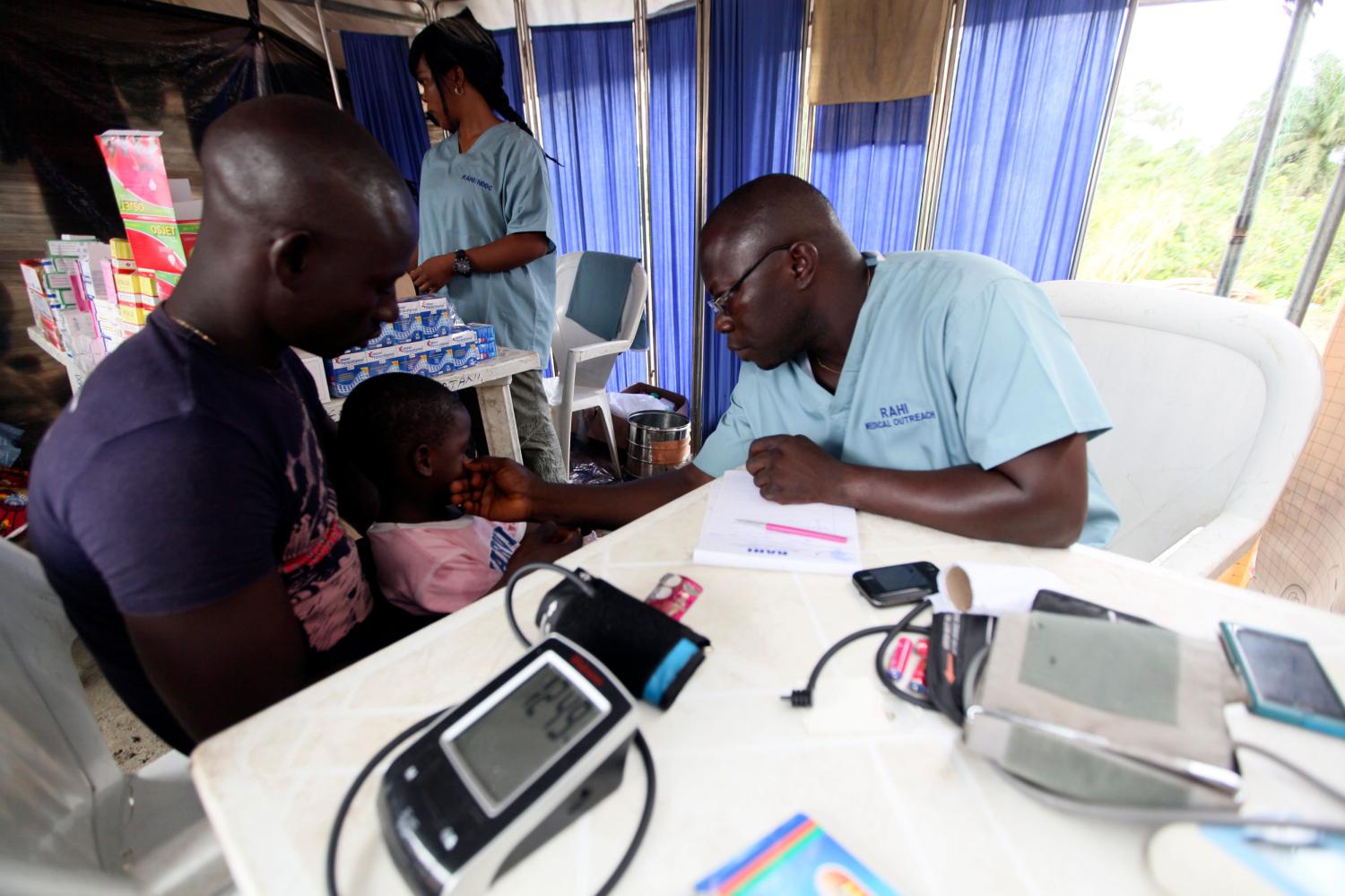 A doctor attends to a child at a relief centre for flood victims in Patani community in Nigeria's Delta state October 14, 2012. Nigerian President Goodluck Jonathan on October 11 visited some of the hundreds of thousands of people made homeless by the country's worst flooding in at least five decades, calling it a 'national disaster'. REUTERS/Afolabi Sotunde (NIGERIA - Tags: DISASTER HEALTH) - GM1E8AE1N9001