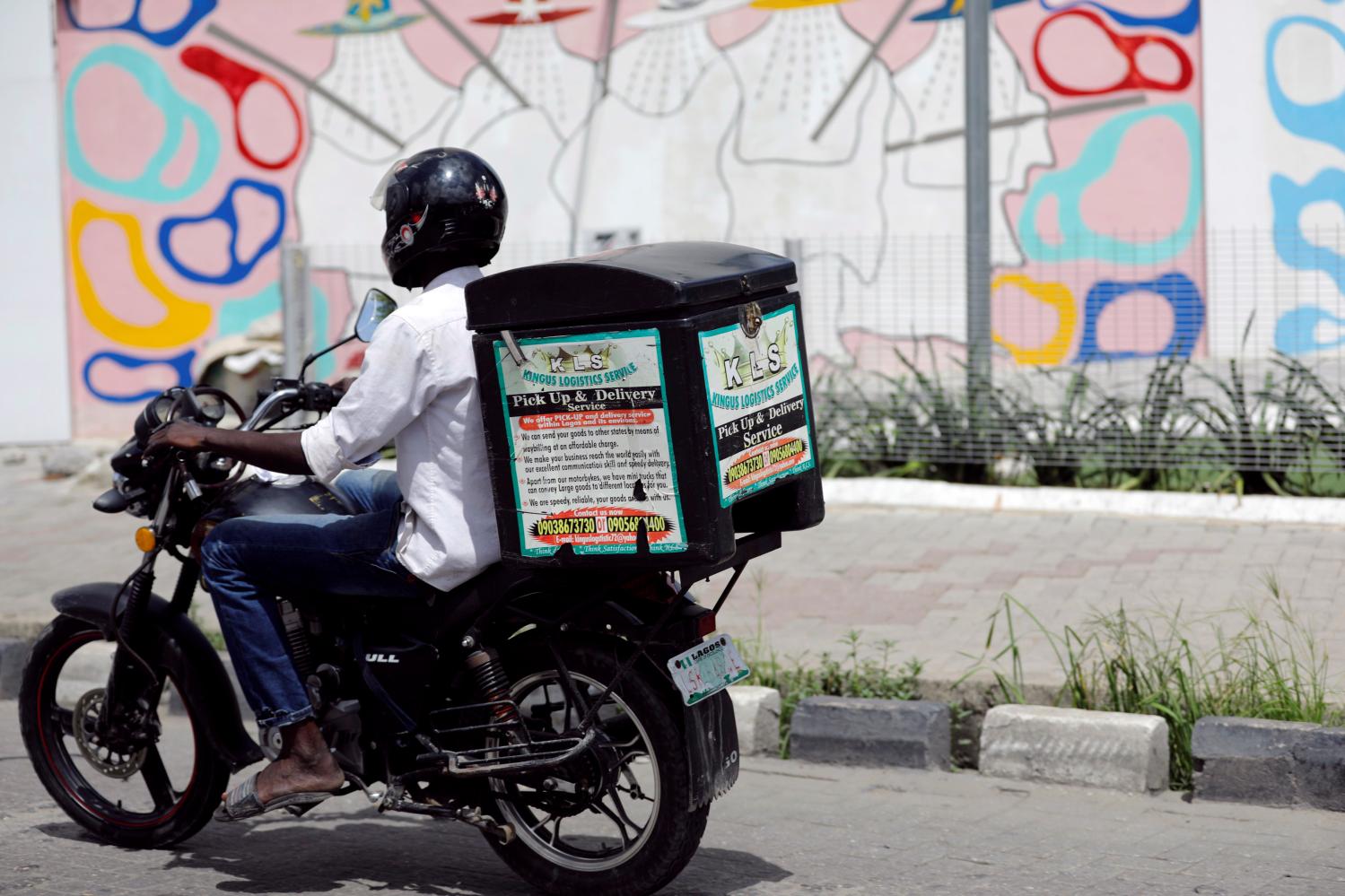 A man rides a motorbike with a delivery box along a road in Ajose Adeogun district in Victoria Island, Lagos, Nigeria June 4, 2018. Picture taken June 4, 2018. REUTERS/Akintunde Akinleye - RC1C91FE5F80
