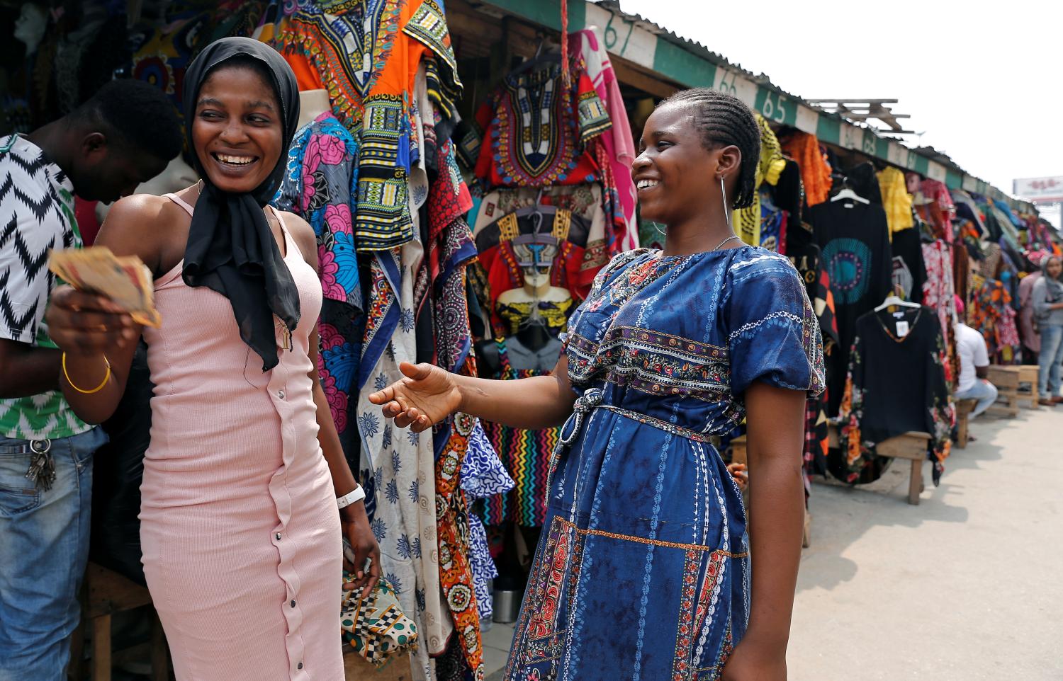 Clothes sellers exchange money in Marina, in Nigeria's commercial capital of Lagos, Nigeria February 11, 2019. REUTERS/Nyancho NwaNri - RC1C4E42FD10