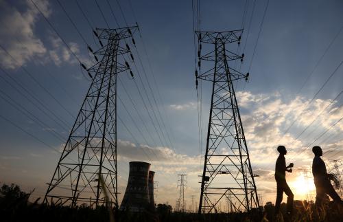 Boys walk past electricity pylons and the cooling towers of the defunct Orlando Power Station in Soweto, South Africa, June 28, 2018. Picture taken June 28, 2018. REUTERS/Siphiwe Sibeko - RC164C8E8250
