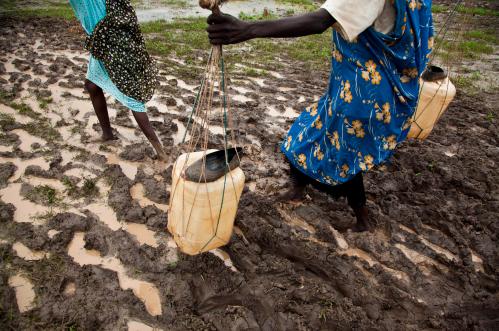 Women carry water through the flooded Jamam refugee camp in South Sudan's Upper Nile July 1, 2012. REUTERS/Adriane Ohanesian (SOUTH SUDAN - Tags: SOCIETY ENVIRONMENT) - GM1E87217LH01
