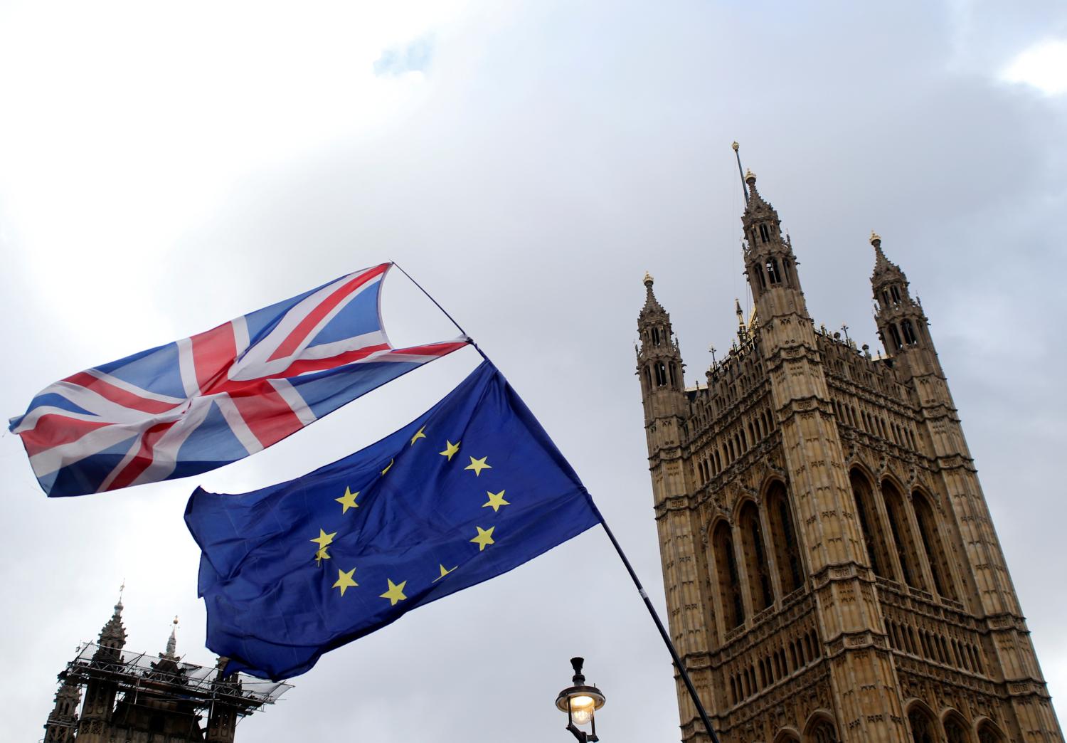 Flags flutter outside the Houses of Parliament, ahead of a Brexit vote, in London, Britain March 13, 2019. REUTERS/Tom Jacobs - RC1321F804E0