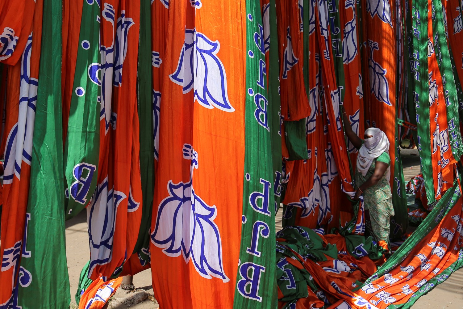 A worker pulls a roll of flags of India's ruling Bharatiya Janata Party (BJP) party kept for drying at a flag manufacturing factory, ahead of the 2019 general elections, in Ahmedabad, India, March 15, 2019. REUTERS/Amit Dave - RC120850C5B0