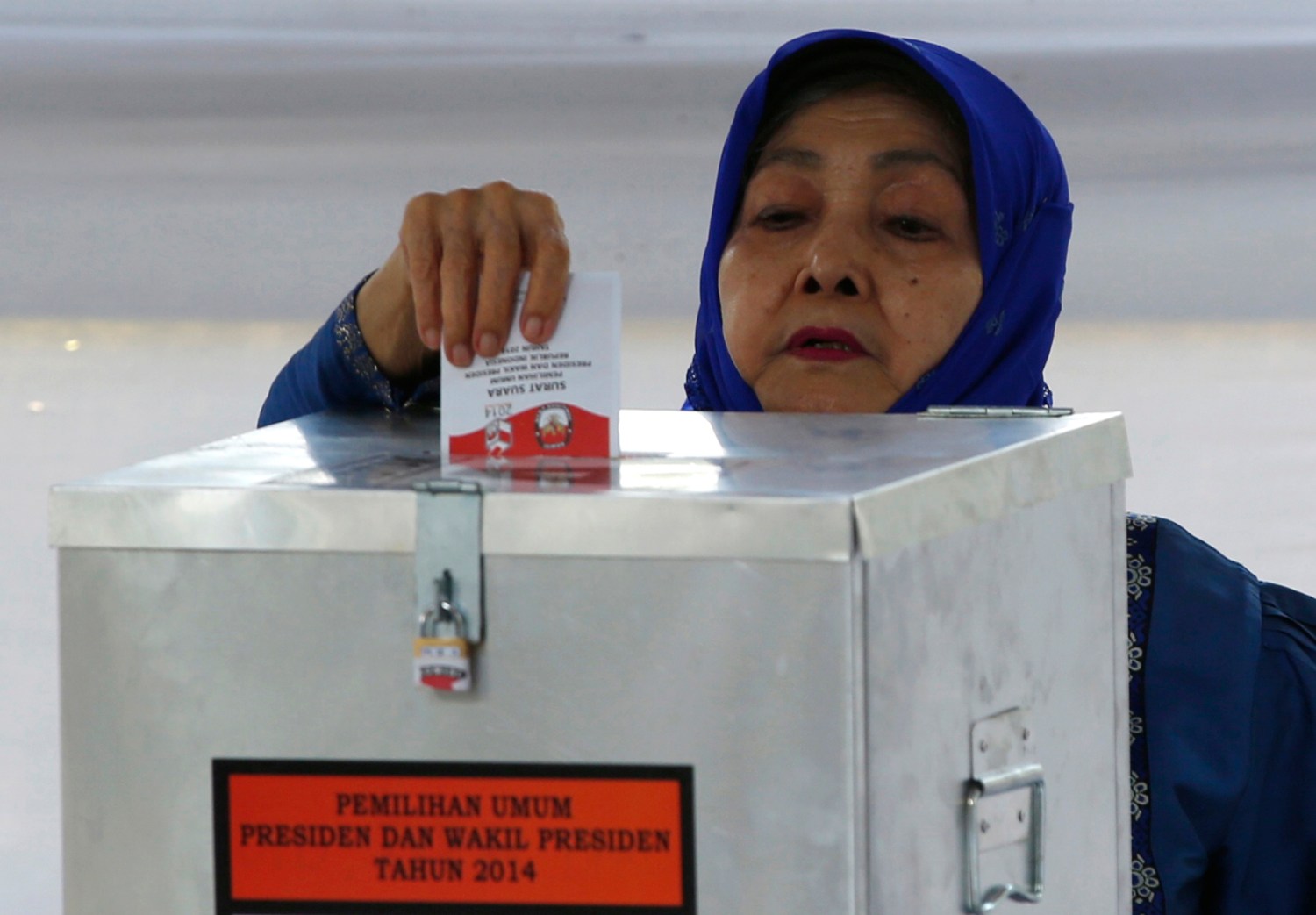 A voter casts her ballot at a polling station, where Indonesian presidential candidate Joko "Jokowi" Widodo and his wife Iriana, will cast their vote later in Jakarta July 9, 2014. Indonesians voted in a presidential election on Wednesday that has become a closely fought contest between the old guard who flourished under decades of autocratic rule and a new breed of politician that has emerged in the fledgling democracy.Only the third direct election for a president in the world's fourth-most populous state, the contest pits former special forces general Prabowo Subianto against Jakarta Governor Joko "Jokowi" Widodo, who have been running neck-and-neck in opinion polls. REUTERS/Darren Whiteside (INDONESIA - Tags: ELECTIONS POLITICS) - GM1EA79192401
