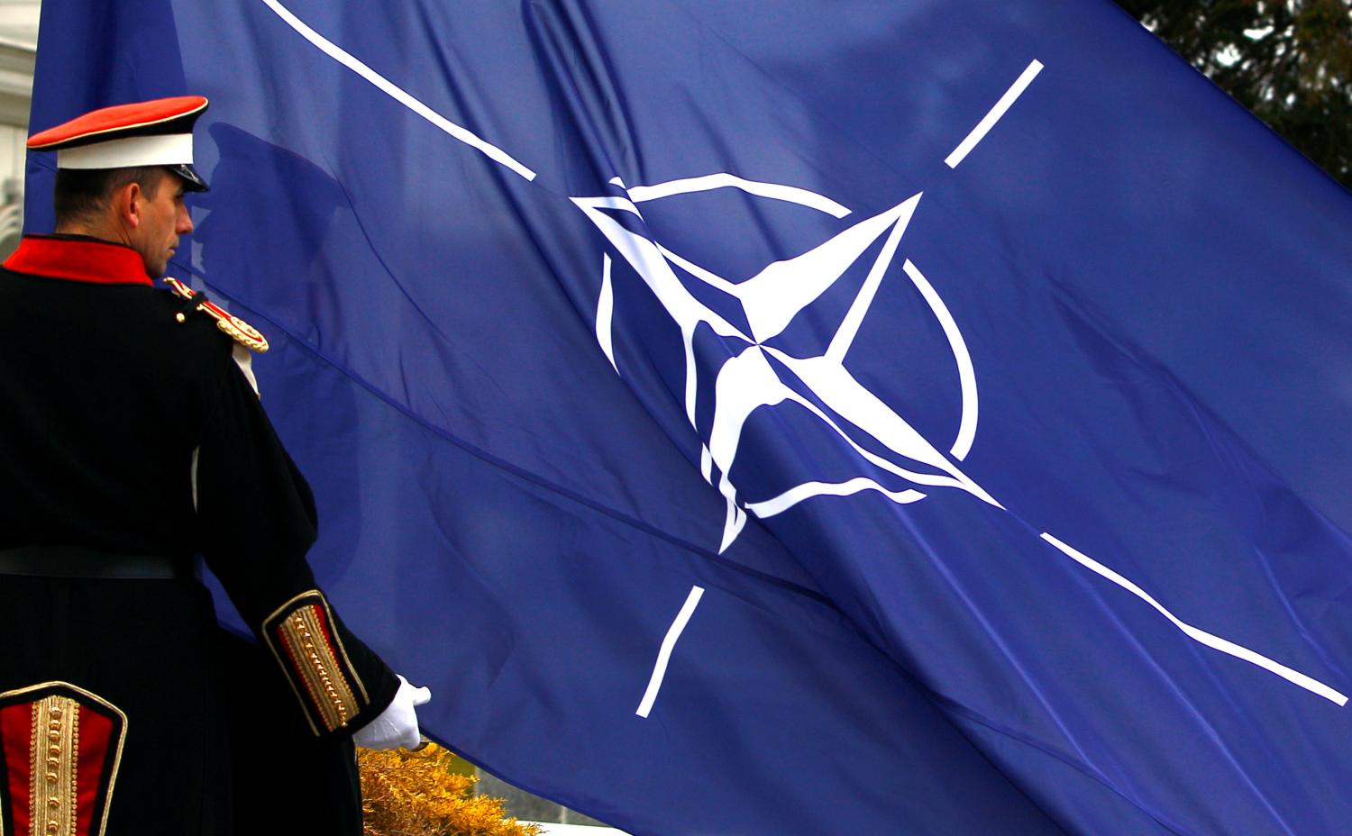 An honor guard raises the NATO flag in front of the Macedonian government in Skopje, February 12, 2019. REUTERS/Ognen Teofilovski - RC1DABE40230