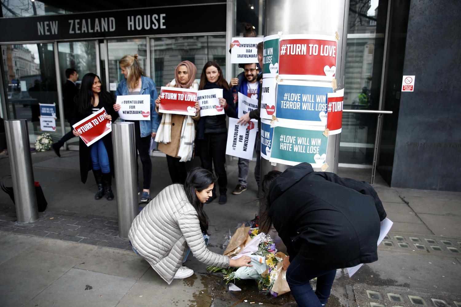 People lay flowers outside New Zealand House, following Christchurch mosque attack in New Zealand, in London, Britain March 15, 2019. REUTERS/Henry Nicholls - RC178C0E1510