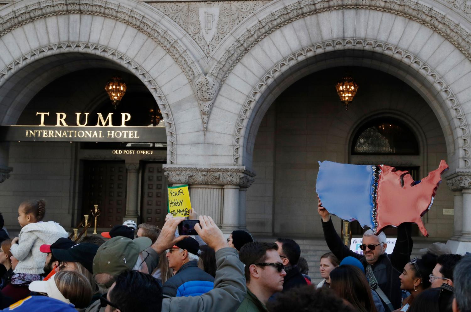 A demonstrator protests with a sign showing a divided Red and Blue America in front of the Trump International Hotel during the "March for Our Lives" event demanding gun control after recent school shootings at a rally in Washington, U.S., March 24, 2018. REUTERS/Leah Millis - HP1EE3O1FJKIW