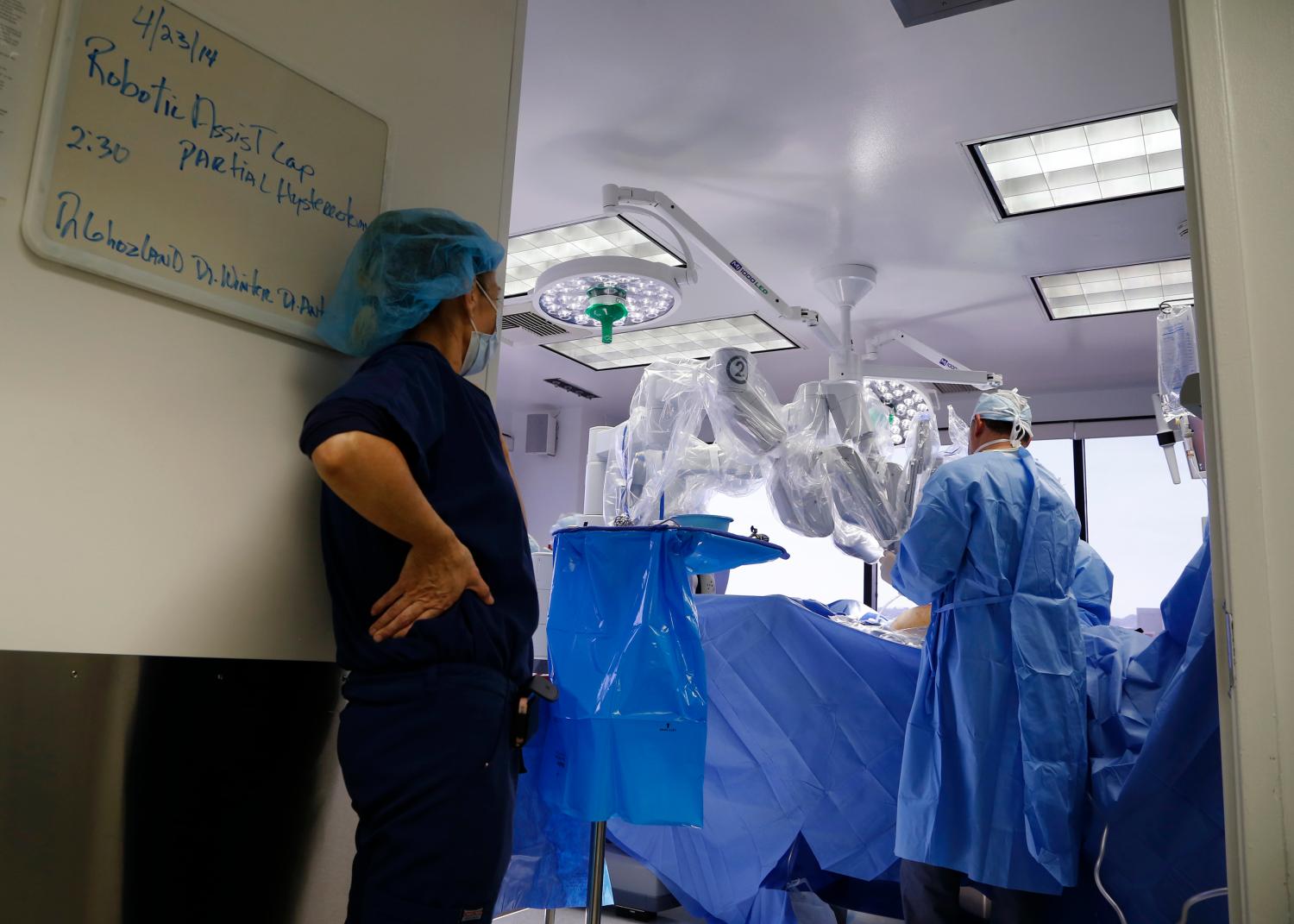 Doctors perform a single-site robotic-assisted hysterectomy on a 49-year-old woman, Sheryl, who had two fibroids, at miVIP Surgery Center,  in Los Angeles, California April 23, 2014. REUTERS/Lucy Nicholson (UNITED STATES - Tags: HEALTH SOCIETY SCIENCE TECHNOLOGY) - GM1EA4O0TE101
