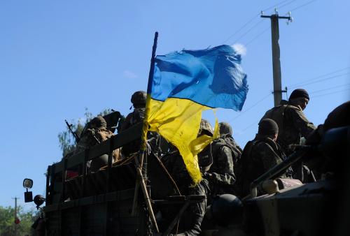 Ukrainian soldiers drive a military vehicle with a torn Ukrainian flag at a checkpoint near Slaviansk in eastern Ukraine July 3, 2014. About half the 130,000 residents of Slaviansk are thought to have fled since fighters who want eastern Ukraine incorporated into Russia took control of the city in April, a month after Moscow annexed the Black Sea peninsula of Crimea. Since then, government forces trying to end the rebellion in towns and cities across the Russian-speaking region have pounded separatist positions in and around Slaviansk. Picture taken July 3, 2014. REUTERS/Andrew Kravchenko/Pool (UKRAINE - Tags: POLITICS CIVIL UNREST MILITARY TPX IMAGES OF THE DAY) - GM1EA7414HR01