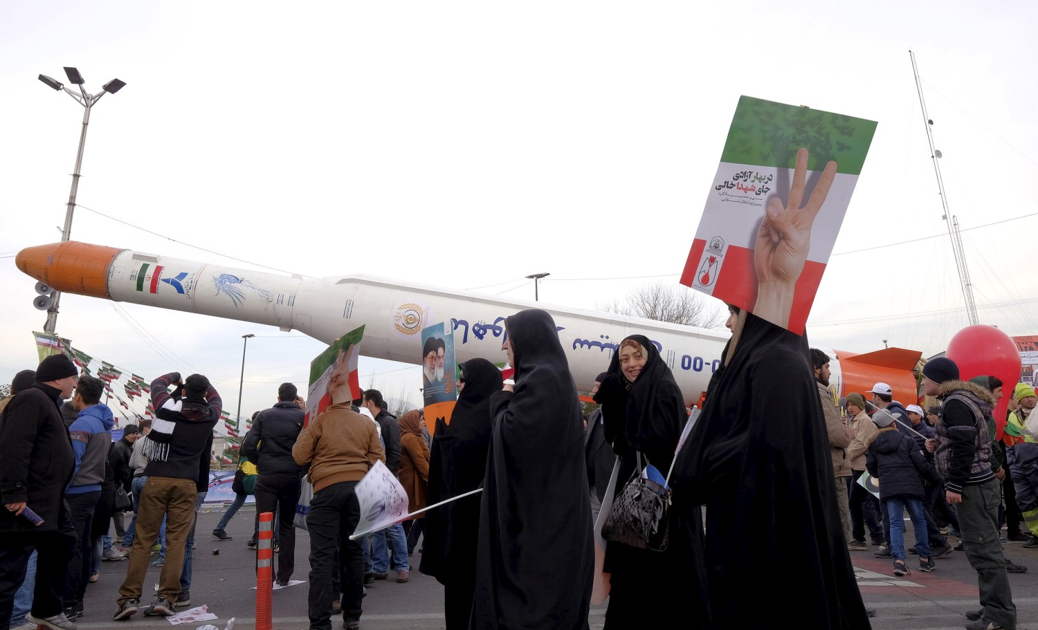 People gather around a model of Simorgh satellite-carrier rocket displayed during a ceremony marking the 37th anniversary of the Islamic Revolution, in Tehran February 11, 2016. REUTERS/Raheb Homavandi/TIMA ATTENTION EDITORS - THIS IMAGE WAS PROVIDED BY A THIRD PARTY. FOR EDITORIAL USE ONLY. - GF10000304500