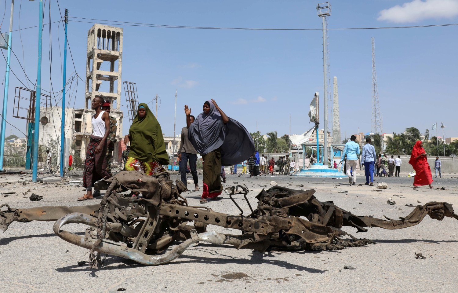 Somali women walk past the wreckage of a car involved in an explosion near the president's residence in Mogadishu, Somalia December 22, 2018. REUTERS/Feisal Omar - RC195E3B8230