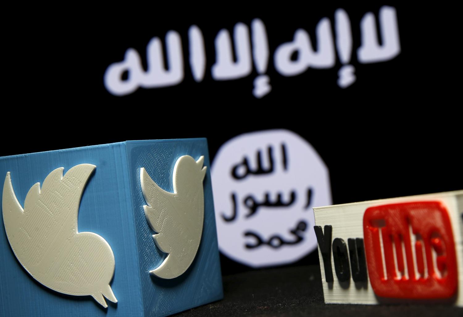 A 3D plastic representation of the Twitter and Youtube logo is seen in front of a displayed ISIS flag in this photo illustration in Zenica, Bosnia and Herzegovina, February 3, 2016. Iraq is trying to persuade satellite firms to halt Internet services in areas under Islamic State's rule, seeking to deal a major blow to the group's potent propaganda machine which relies heavily on social media to inspire its followers to wage jihad. Picture taken February 3, 2016. To match Insight MIDEAST-CRISIS/IRAQ-INTERNET REUTERS/Dado Ruvic - GF10000295345