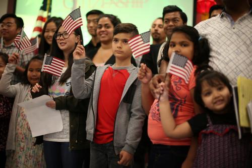 Children say the pledge of allegiance during a ceremony to present citizenship certificates to young people who earned citizenship through their parents, in Los Angeles, California, U.S., May 31, 2017. REUTERS/Lucy Nicholson - RC1E23D956B0