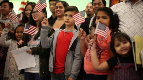 Children say the pledge of allegiance during a ceremony to present citizenship certificates to young people who earned citizenship through their parents, in Los Angeles, California, U.S., May 31, 2017. REUTERS/Lucy Nicholson - RC1E23D956B0
