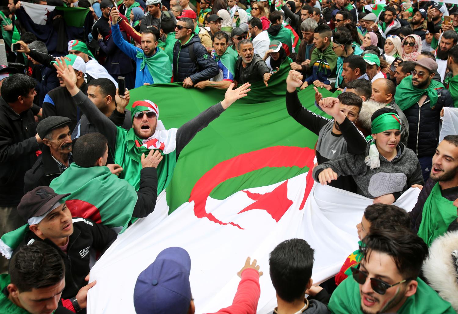 People carry a national flag during a protest to push for the removal of the current political structure, in Algiers, Algeria April 5, 2019. REUTERS/Ramzi Boudina - RC11F4580FD0