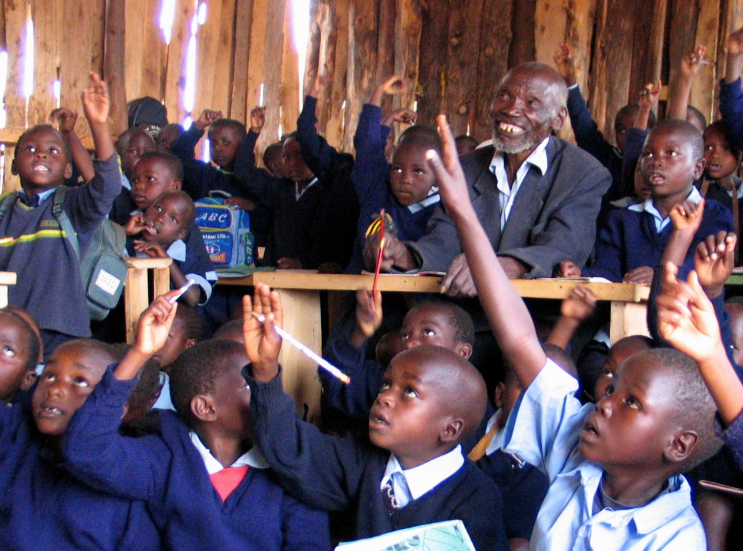 Kimani Murage, an 84-year-old Kenyan grandfather who has 30 grandchildren, attends lessons with classmates January 15, 2004 at a primary school after the government introduced free primary education last year. Murage, who was part of the Mau Mau movement that fought against British colonial rule in Kenya in the 1950s, has classmates whose average age is seven years old, and two of his grandchildren attend more advanced classes in the same school in Kenya's Eldoret district, some 270 km (162 miles) northwest of the capital Nairobi. REUTERS/Beatrice Mategwa  PP04010048 RS/ACM - RP4DRIGLUBAC