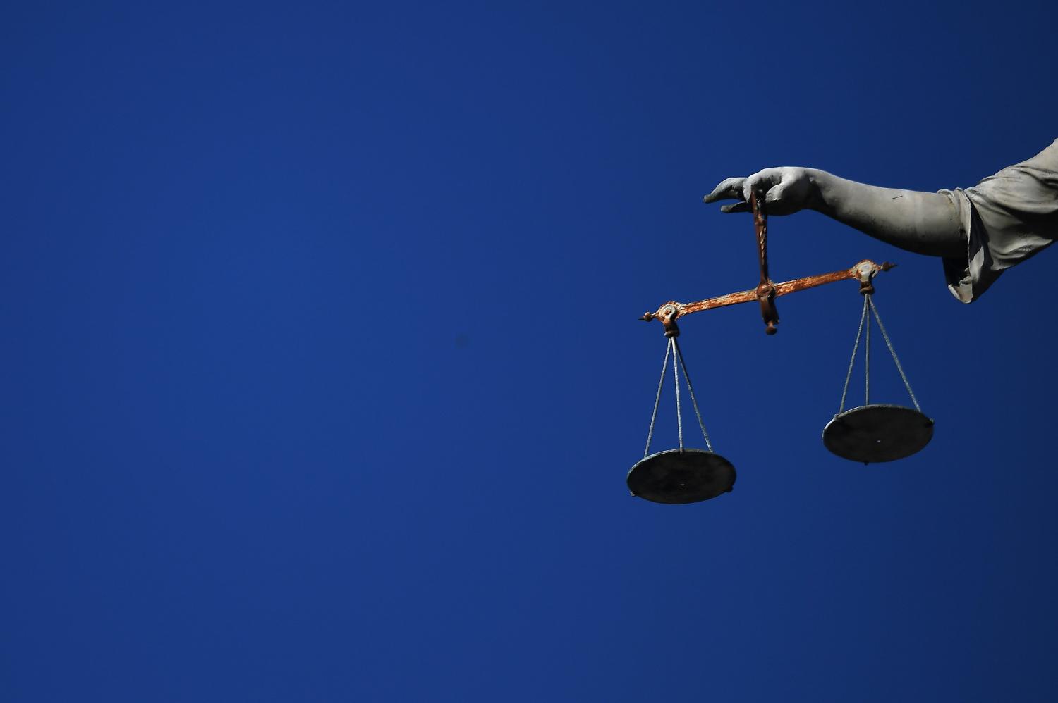 Balance scales are seen hanging from a statue in Dublin Castle in Dublin, Ireland October 15, 2018. REUTERS/Clodagh Kilcoyne - RC1991A87A10