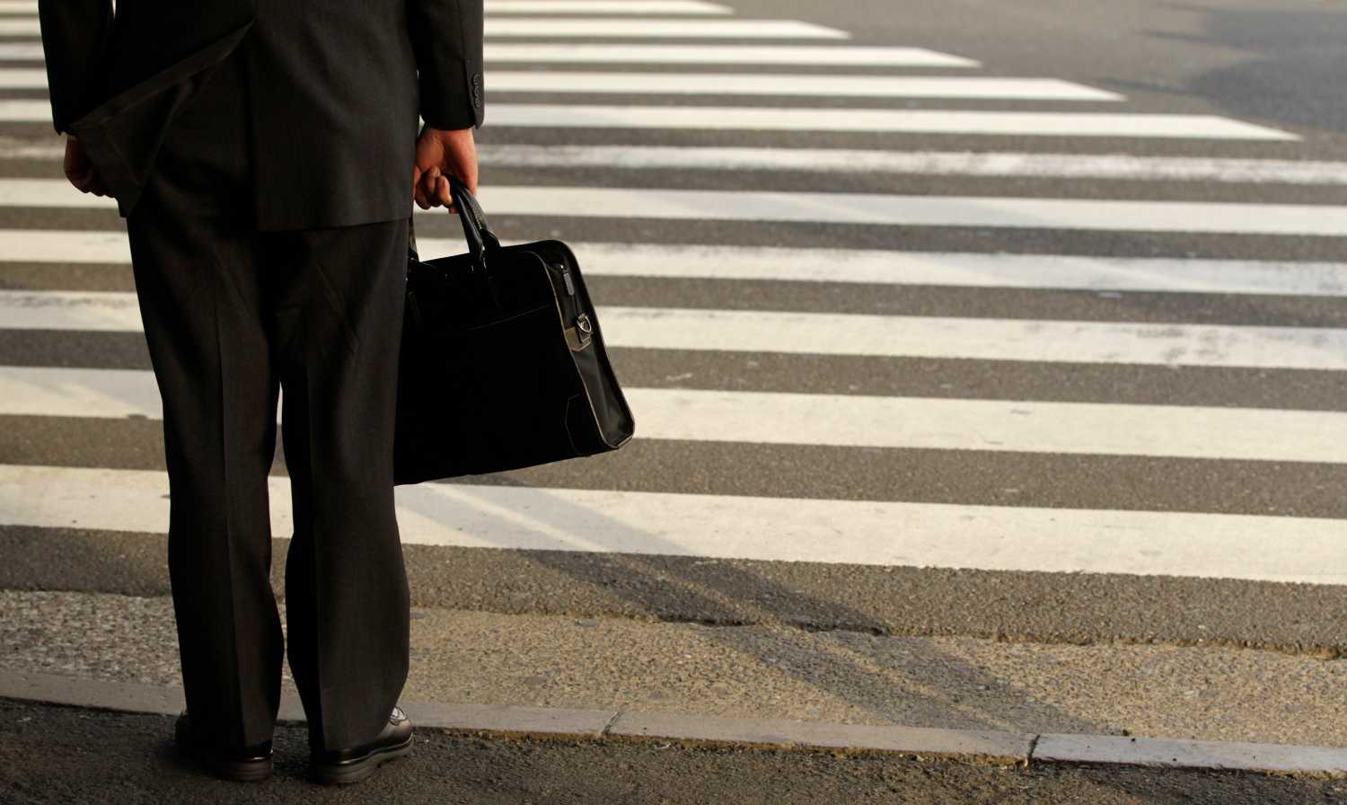 A businessman waits to cross a street in Tokyo April 4, 2011. Japanese big manufacturers expect conditions to worsen significantly in the next three months, responses to a Bank of Japan survey collected after the March 11 earthquake showed on Monday.   REUTERS/Yuriko Nakao (JAPAN - Tags: EMPLOYMENT BUSINESS POLITICS) - GM1E7441E6E01