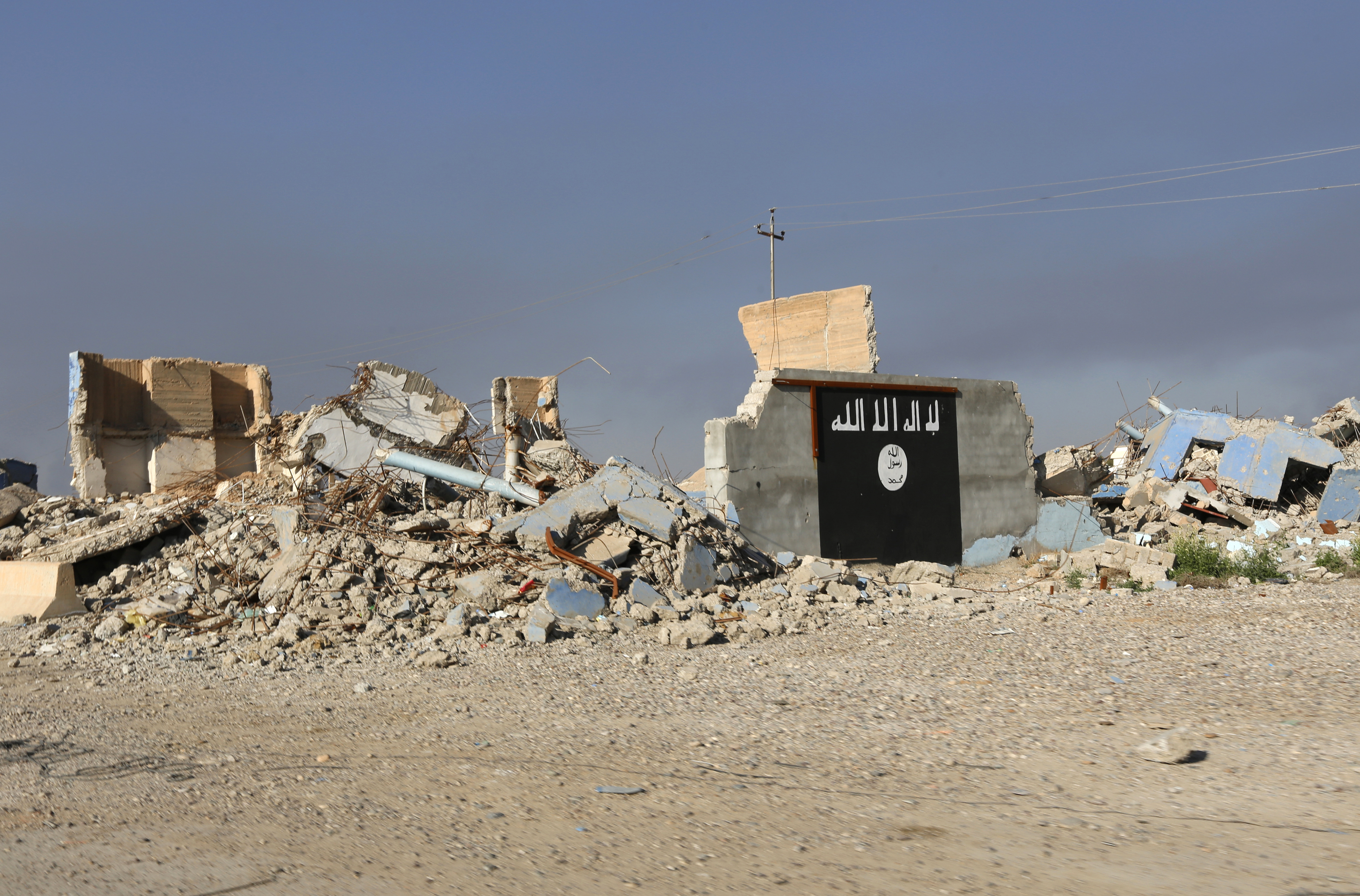 A destroyed building with a wall painted with the black flag commonly used by Islamic State militants, is seen in the town of al-Alam March 10, 2015. Iraqi troops and militias drove Islamic State insurgents out of al-Alam on Tuesday, clearing a final hurdle before a planned assault on Saddam Hussein's home city of Tikrit in their biggest offensive yet against the ultra-radical group. REUTERS/Thaier Al-Sudani (IRAQ - Tags: POLITICS CIVIL UNREST CONFLICT) - GM1EB3B0J4201