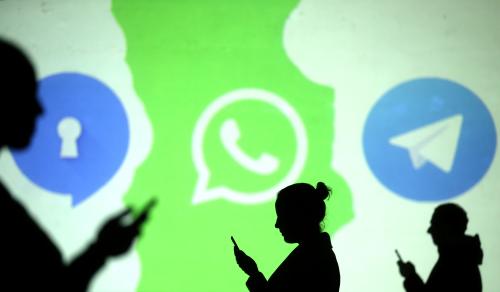 Silhouettes of mobile users are seen next to logos of social media apps Signal, Whatsapp and Telegram projected on a screen in this picture illustration taken March 28, 2018.  REUTERS/Dado Ruvic/Illustration - RC147CF8D300