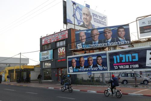 Cyclists ride past a Likud party election campaign billboard depicting Israeli Prime Minister Benjamin Netanyahu and billboards depicting Benny Gantz, leader of Blue and White party, together with his top party candidates Moshe Yaalon, Yair Lapid and Gaby Ashkenazi, in Petah Tikva, Israel April 7, 2019. REUTERS/Nir Elias - RC1711986540