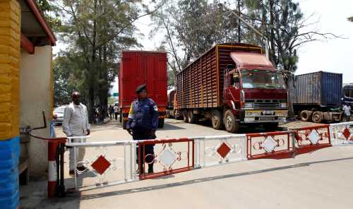 A Congolese policewoman and customs officials secure the gate barriers at their border crossing point with Rwanda in Goma town in the eastern Democratic Republic of Congo, August 29, 2013. REUTERS/Thomas Mukoya/File Photo - S1BETDUZYLAA