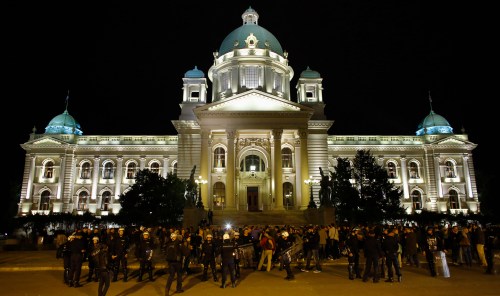 Participants and riot police stand in front of the Serbian Parliament building in Belgrade September 27, 2013. Serbia's government banned a weekend gay pride march for the third consecutive year on Friday, citing the threat of violence from right-wing hooligans, in a move that sparked protests by gay activists and criticism from the European Union. Around 200 gay activists waving rainbow flags and banners that read "This is Pride" gathered outside Prime Minister Ivica Dacic's government office before walking to parliament flanked by riot police.  REUTERS/Marko Djurica (SERBIA - Tags: SOCIETY CIVIL UNREST POLITICS CRIME LAW) - GM1E99S0J6801