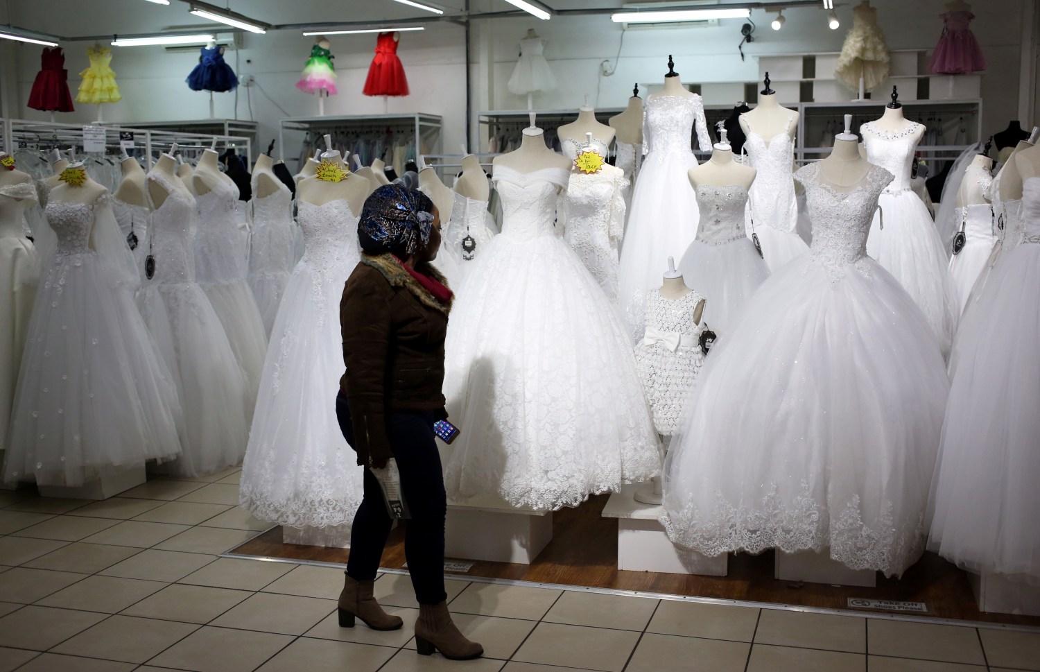 A customer walks past wedding dresses at a bridal shop ih Johannesburg, South Africa May 14, 2018. REUTERS/Siphiwe Sibeko - RC12B1DF4210