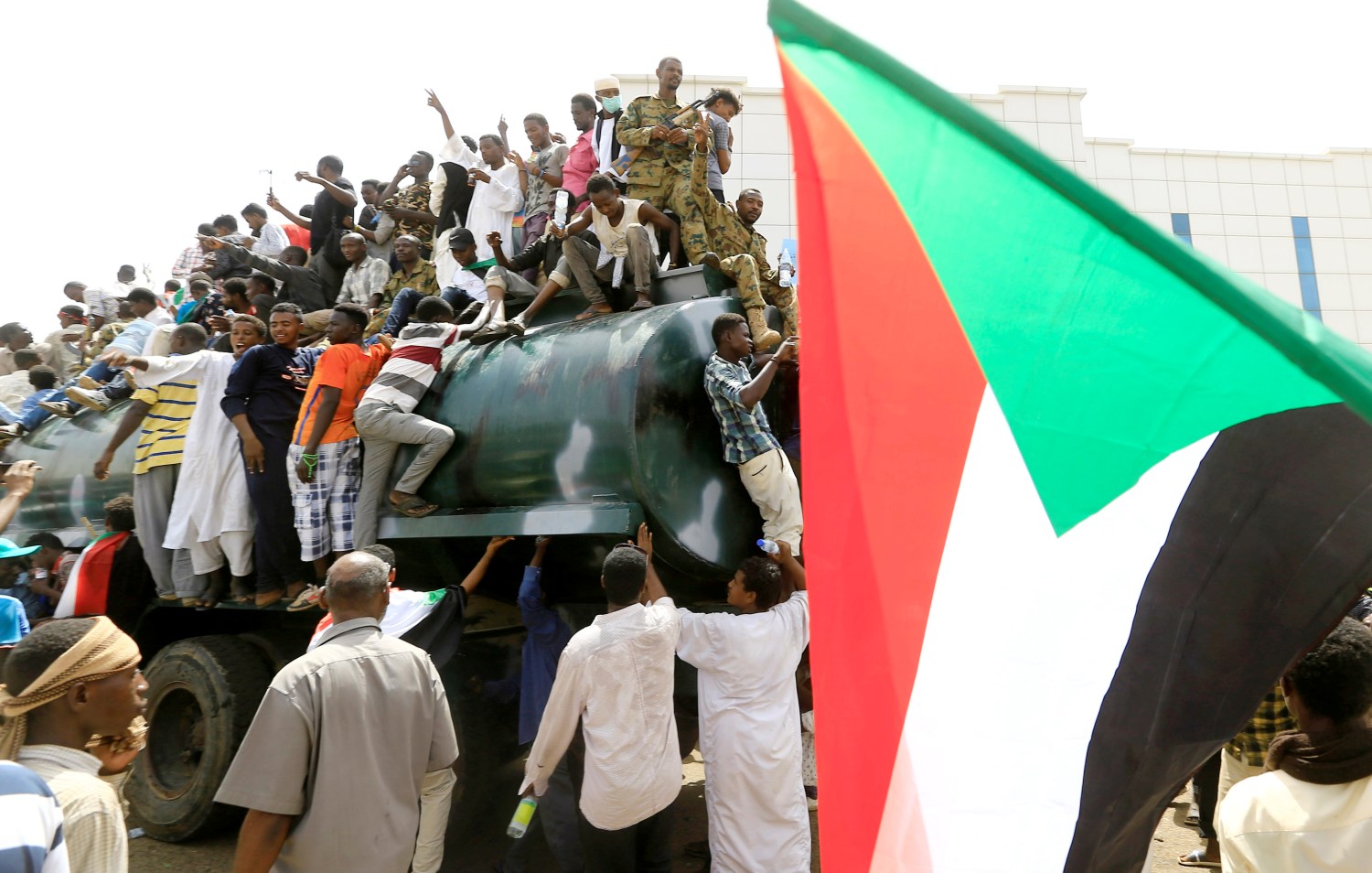 Sudanese military officers and demonstrators ride atop a military tanker as they protest against the army's announcement that President Omar al-Bashir would be replaced by a military-led transitional council, near Defence Ministry in Khartoum, Sudan April 12, 2019. REUTERS/Stringer - RC1BA0866340