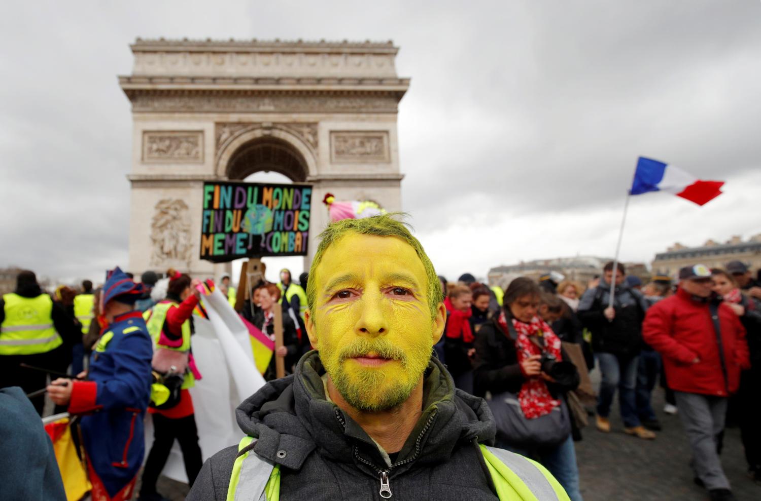 A protester wearing a yellow vest and with his face painted yellow walks down the Champs Elysees during a demonstration by the "yellow vests" movement in Paris, France, march 9, 2019.  REUTERS/Philippe Wojazer - RC1B5A4470C0