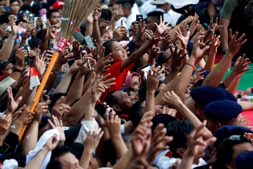 Supporters reach for a t-shirt at a carnival during a campaign rally of the Indonesia's president and presidential candidate for the next election Joko Widodo and his running mate for the upcoming election Ma'ruf Amin in Tangerang, Banten province, Indonesia, April 7, 2019. REUTERS/Willy Kurniawan - RC1C252882E0