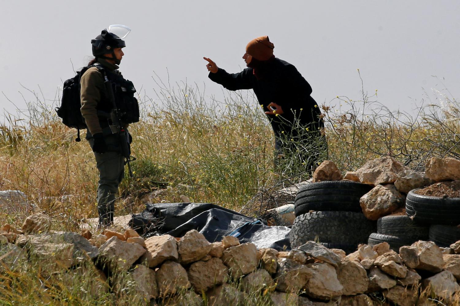 A Palestinian woman argues with an Israeli border policewoman over the removal of a Palestinian tent whose owners said they were informed by the Israeli forces that they didnt obtain a permit to erect the tent, in Susiya village in the Israeli-occupied West Bank April 18, 2019. REUTERS/Mussa Qawasma - RC15417709C0