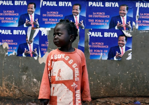 A girl stands near a wall covered with Placards of Cameroon President Paul Biya, who runs for reelection scheduled for October 7, in Yaounde, Cameroon October 5, 2018. REUTERS/Zohra Bensemra - RC1BA30D24C0