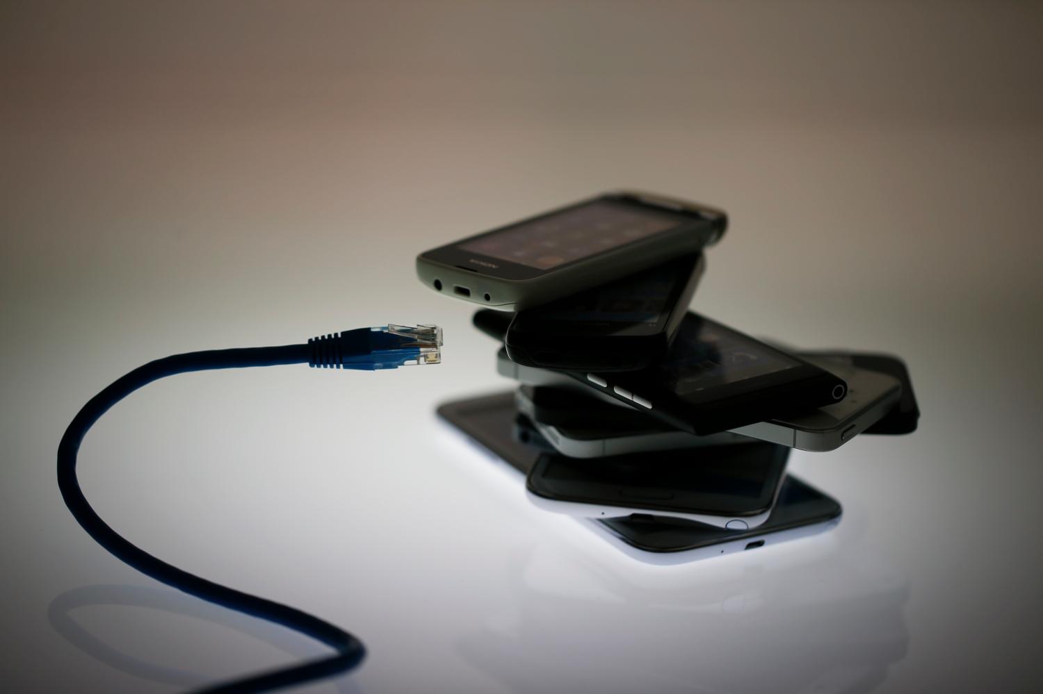 An illustration picture shows a network cable next to a pack of smartphones in Berlin, June 7, 2013. The debate over whether the U.S. government is violating citizens' privacy rights while trying to protect them from terrorism escalated dramatically on Thursday amid reports that authorities have collected data on millions of phone users and tapped into servers at nine internet companies.   REUTERS/Pawel Kopczynski   (GERMANY - Tags: POLITICS SOCIETY BUSINESS) - BM2E967131Y01