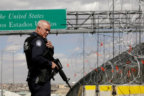 A U.S. Border and Customs and Border Protection (CBP) official stands next a concrete K-rail with concertina wire at Cordova-Americas bridge to enhance security efforts in preparation for increasing number of migrants arriving at the border, as seen from Ciudad Juarez, Mexico February 22, 2019. REUTERS/Jose Luis Gonzalez - RC1F2181F4D0