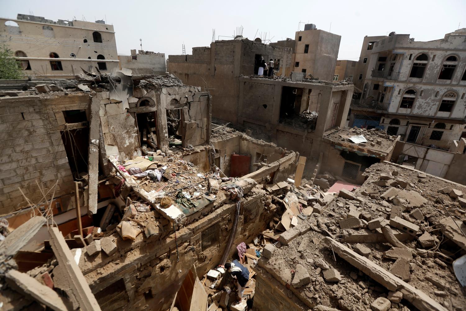 A man searches in the rubble of a house destroyed by an air strike in Amran, Yemen June 25, 2018. REUTERS/Khaled Abdullah - RC1C1F459690