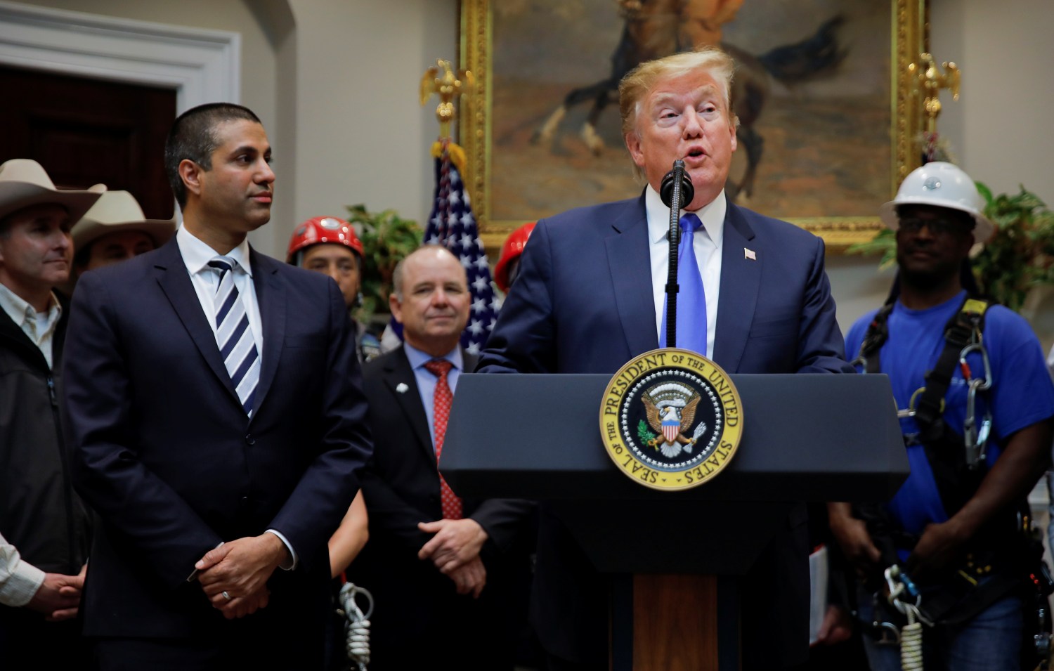 U.S. President Donald Trump speaks next to Federal Communications Commission (FCC) Commissioner Ajit Pai during an event on United States 5G deployment in the Roosevelt Room of the White House in Washington, U.S., April 12, 2019. REUTERS/Carlos Barria - RC19EF413F60