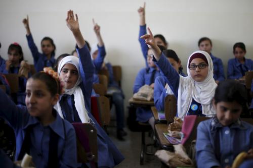 Students raise their hands as they attend class and eat a meal distributed as part of a World Food Programme (WFP)-run project to provide healthy meals to students and to raise awareness of good eating habits, at Hofa Al-Mazar school in the city of Irbid, Jordan, April 26, 2016. REUTERS/ Muhammad Hamed - GF10000396485